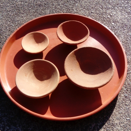 Photo of 4 handmade clay saucers on a clay tray